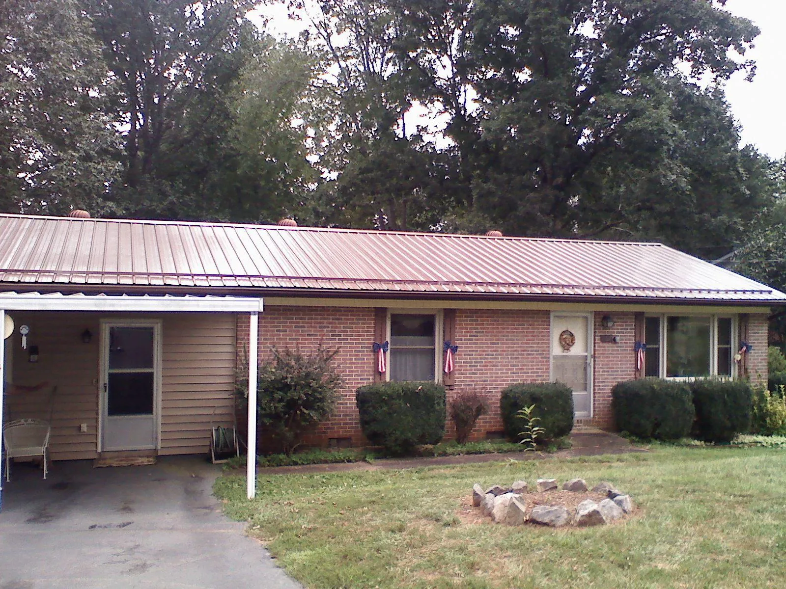 Bronze metal roof and carport on a brick ranch home — Roof Repair work by our crew in Stanwood